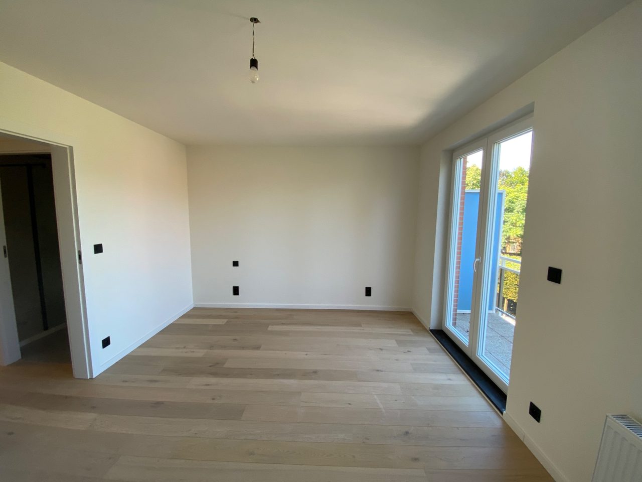 Gerenoveerde leefruimte appartement Herentals met zwarte schakelaars en stopcontacten