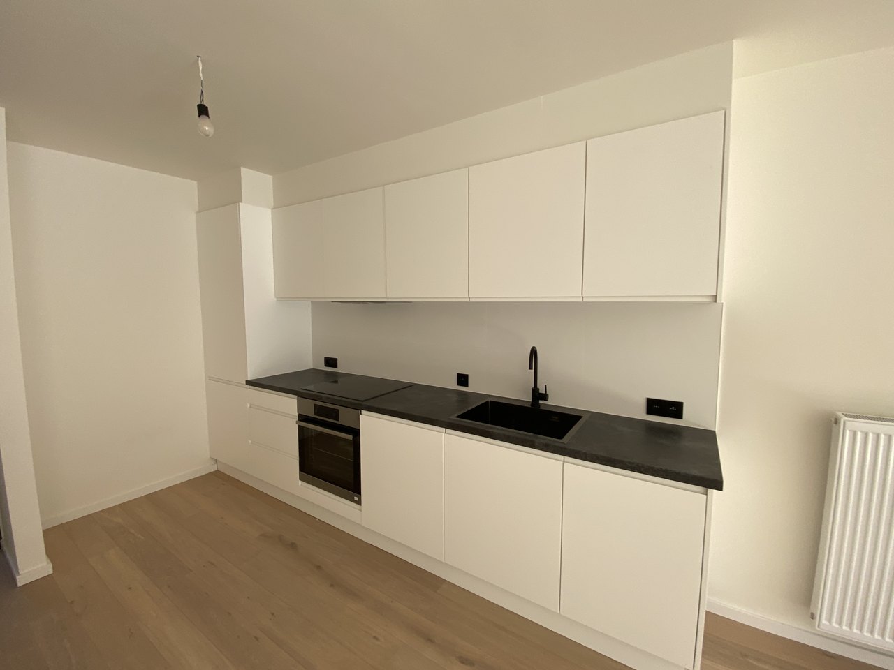 Keuken met zwarte elektrische aansluitpunten in een gerenoveerd appartement