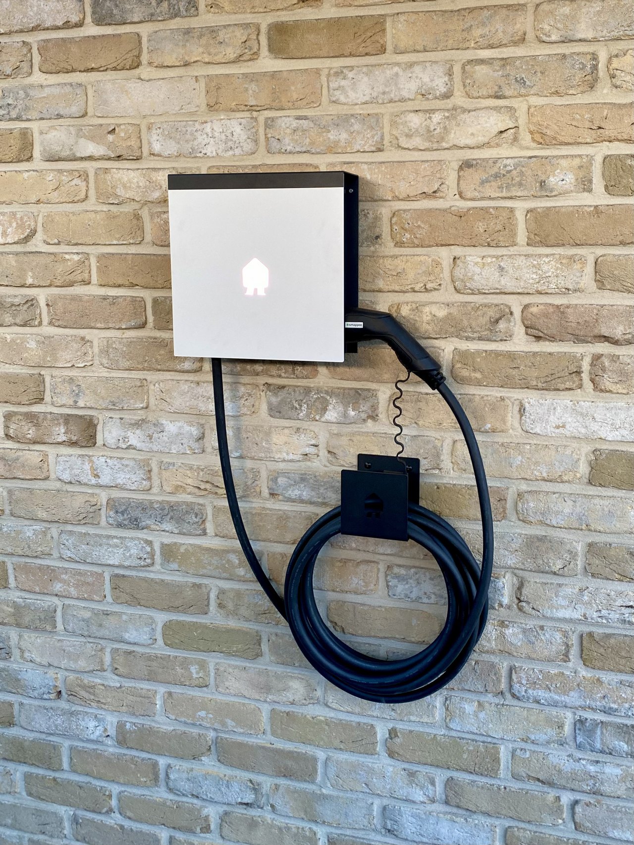 Smappee-laadpaal netjes gemonteerd tegen een bakstenen gevel in Nijlen